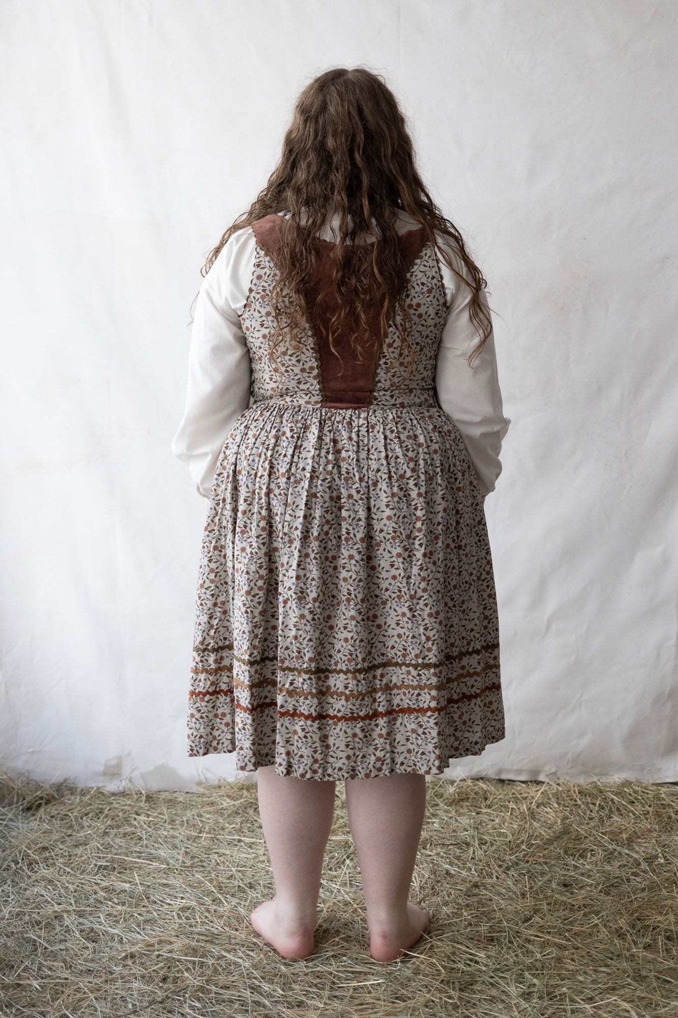 Person wearing a patterned dress with a plain white background