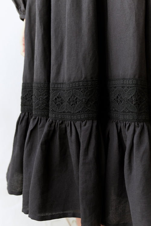 Black dress with lace detailing on a white background