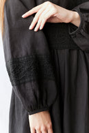 Black dress with lace detailing on a white background