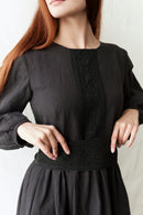 Black dress with intricate detailing on a plain background