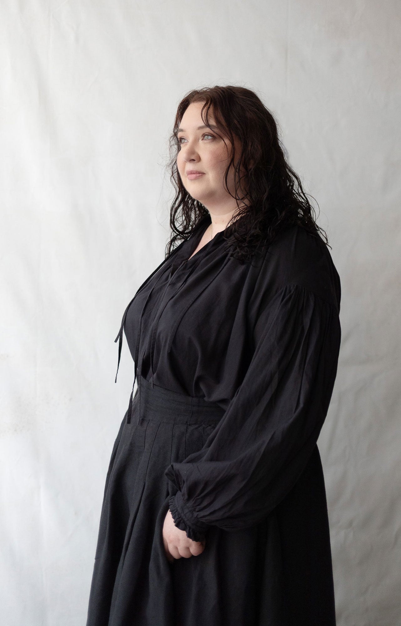 Woman wearing a black dress against a plain background