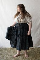 + size Woman wearing a white Hungarian Matyo blouse with floral embroidery against a plain background