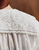 Close-up of a white lace-trimmed garment with a blurred background