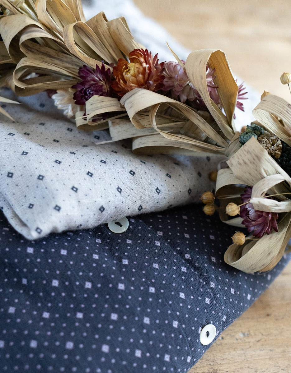 Dried flower arrangement on a polka dot fabric with a blue pattern