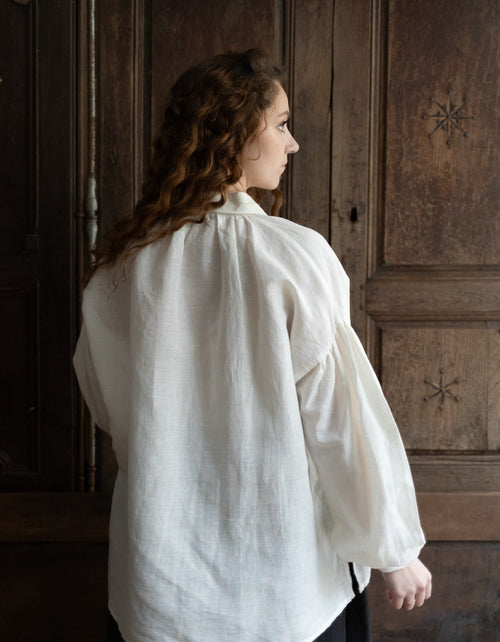 Woman wearing a white shirt in a room with wooden paneling