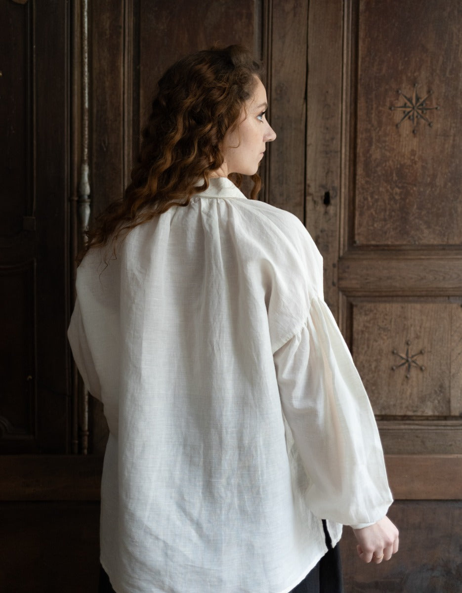 Woman wearing a white shirt in a room with wooden paneling