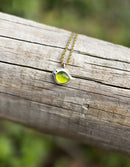 Necklace with a green pendant on a wooden surface